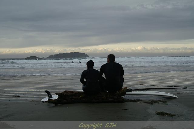 Photo of Surfers sitting contemplating the next wave
